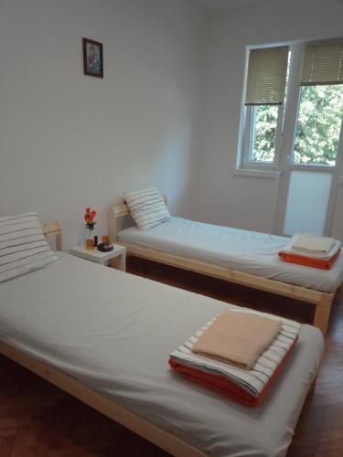 two beds in a room with two windows at Стеди - стая за гости in Varna City