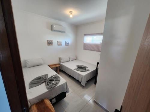 um pequeno quarto com 2 camas e uma janela em Mahalo residence vista mar em Porto de Galinhas