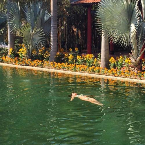 a man swimming in a pool in the water at Full Moon Village Resort in Mui Ne