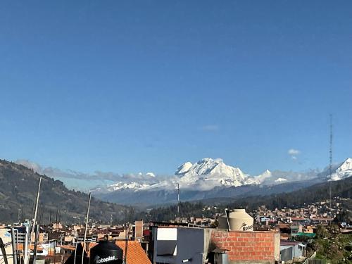 a view of a city with snow capped mountains in the background at La Casa de Zarela in Huaraz