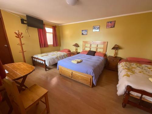 a bedroom with two beds and a tv in it at La Casa de Zarela in Huaraz