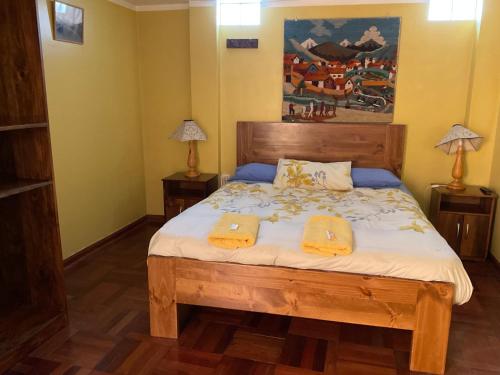 a bedroom with a bed with two towels on it at La Casa de Zarela in Huaraz