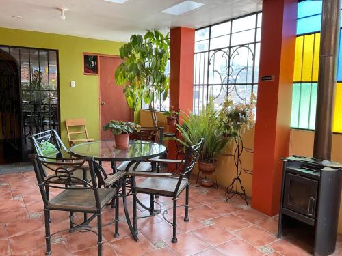 a dining room with a table and chairs and windows at La Casa de Zarela in Huaraz