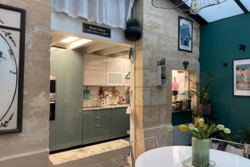 duas fotos de uma cozinha com um balcão num quarto em Pretty house - near botanical garden em Bordéus
