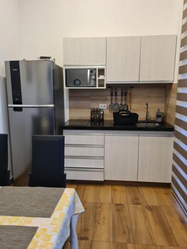a kitchen with white cabinets and a stainless steel refrigerator at BEACH HOUSE Mar Adentro, lugar paradisiaco in Santa Cruz de la Sierra