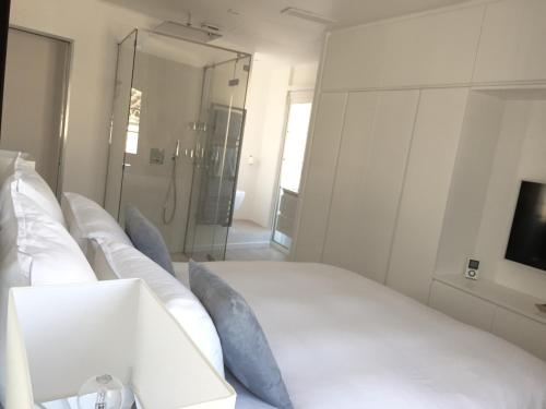sypialnia z dużym białym łóżkiem z niebieskimi poduszkami w obiekcie Duplex Citadelle w Saint-Tropez