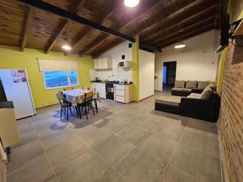 cocina y sala de estar con mesa y sillas. en Alojamiento Zapala - Sakin en Zapala
