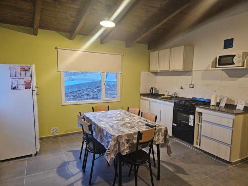 a kitchen with a table with chairs and a window at Alojamiento Zapala - Sakin in Zapala