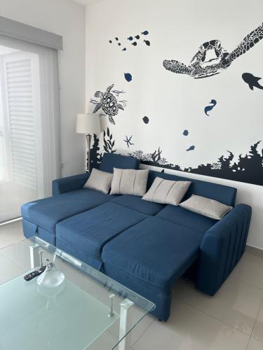 a blue couch in a room with a wall at Torre EME 414 Vista al Mar in Mazatlán