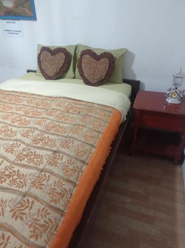 1 cama con 2 almohadas y mesa auxiliar en ESCOCIE-PLAZA G, en Quito