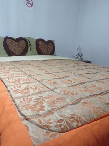 Una cama con edredón en un dormitorio en ESCOCIE-PLAZA G, en Quito