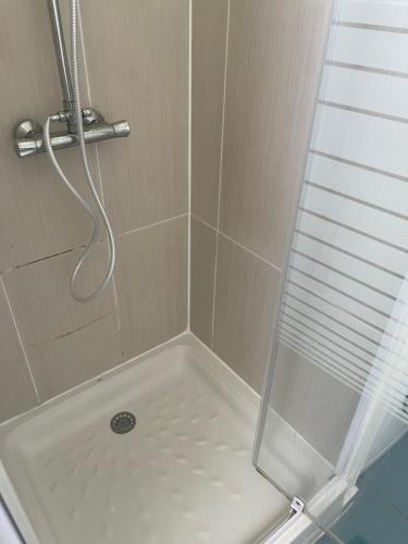 eine Dusche mit einer weißen Badewanne und einer Glastür in der Unterkunft Le Petit Havre de Paix du Gosier in Le Gosier