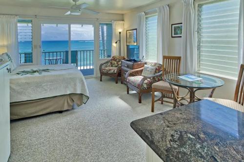 a bedroom with a bed and a table and chairs at Condos in Kapa'a Sands in Kapaa