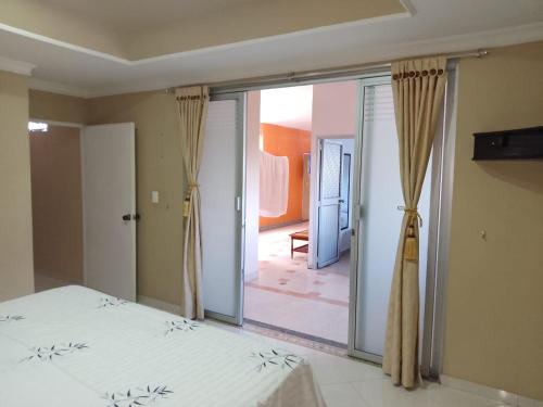1 dormitorio con 1 cama y puerta corredera de cristal en Apartamento duplex Buganaviles, en Neiva