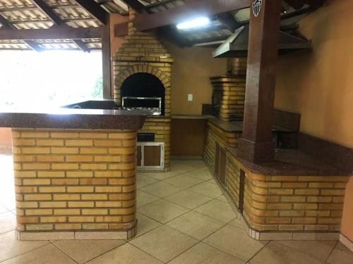 uma cozinha com um balcão de tijolos e um forno em Sítio Santa Terezinha em Divinópolis