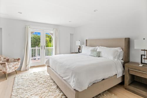Un dormitorio blanco con una cama grande y una ventana en Island in the Sky, en Water Mill