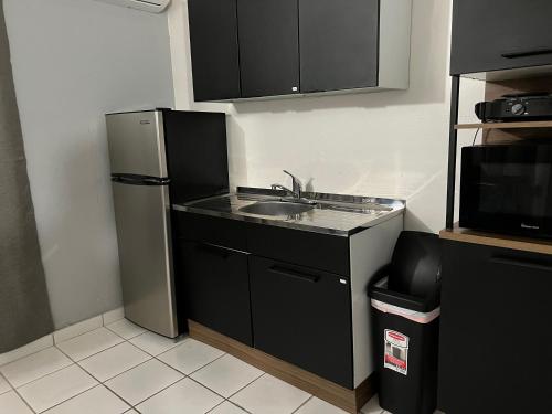 a small kitchen with a sink and a refrigerator at Blu Lime Apartments in San Juan