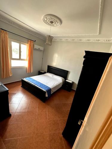 a bedroom with a bed and a window at Spacieux appartement familial in Agadir