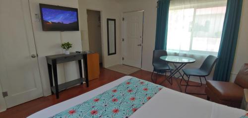 a bedroom with a bed and a table and a television at Rocket Inn in Truth or Consequences