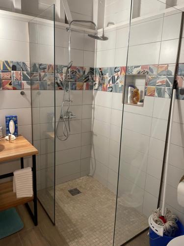 a shower with glass doors in a bathroom at Bungalow Candy avec piscine in Rivière-Salée