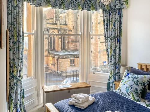 a bedroom with a bed and a large window at Stanton House - Abbey View in Whitby