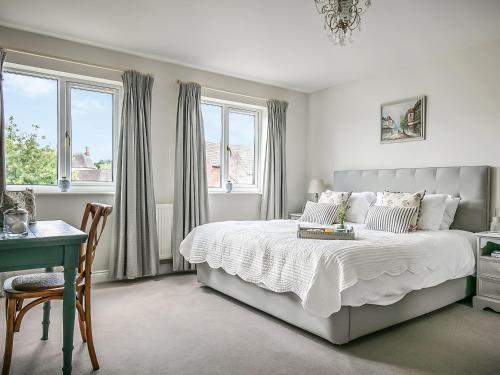 a bedroom with a bed and a desk and windows at The Cherry Tree in Thorney