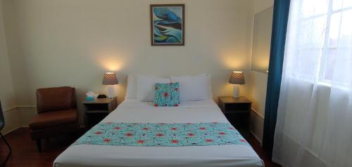 a bedroom with a bed and a chair and a window at Rocket Inn in Truth or Consequences