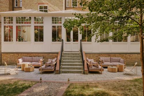 een groep stoelen en trappen voor een gebouw bij Ember Locke Kensington in Londen