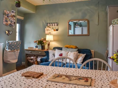 un soggiorno con tavolo e divano di Corner Cottage a Bowness-on-Windermere