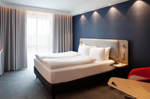 a hotel room with a bed and a window at Holiday Inn Express - Saarbrücken by IHG in Saarbrücken