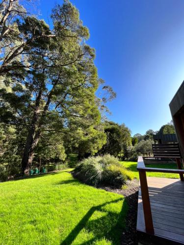 a bench sitting on a wooden deck in a park at Timboon Tiny Homes in Timboon