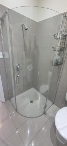 a shower with a glass door in a bathroom at Akaroa Central Apartment in Akaroa
