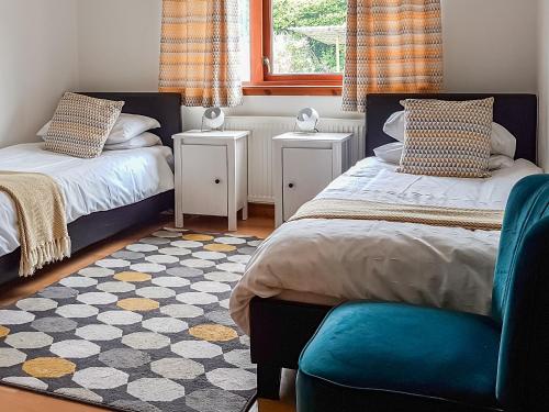 um quarto com 2 camas, uma janela e um tapete em Beech House em Torcastle
