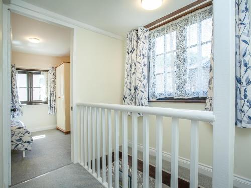 Stokeinteignhead的住宿－The Granary，房屋内的白色楼梯,有窗户
