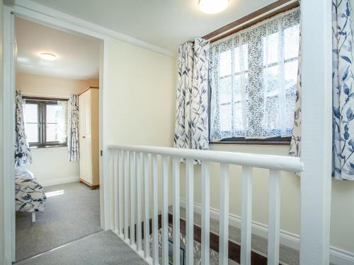 a white staircase in a home with a window at The Granary in Stokeinteignhead