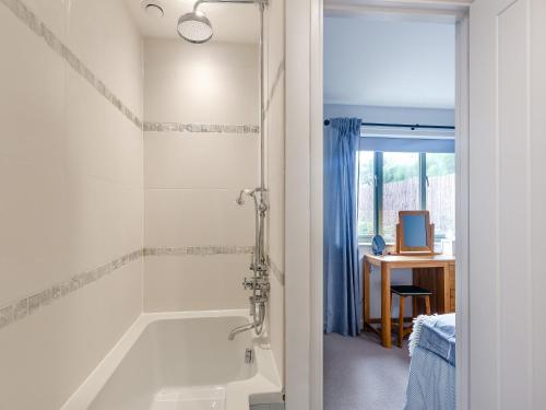 uma casa de banho com uma banheira e uma janela em High Bank em Pontesbury