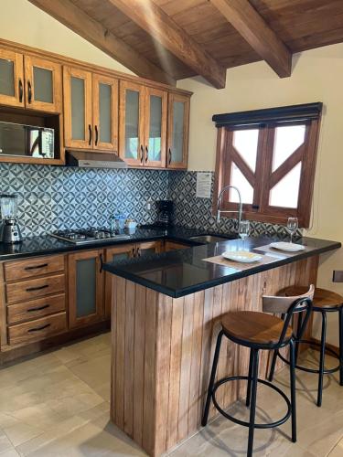 een keuken met houten kasten en een zwart aanrecht bij Cabaña Lunamiel 3 in Mazamitla
