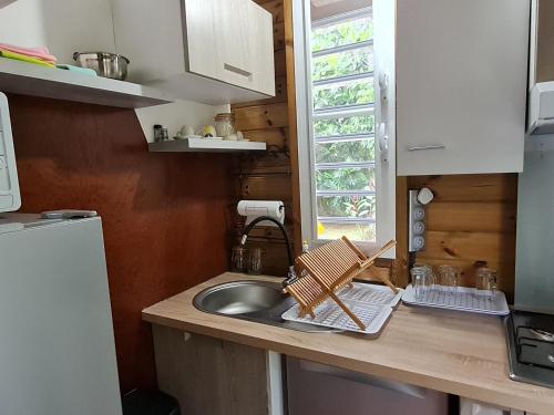 a small kitchen with a sink and a window at La kaz nature bien-être in Petit-Bourg