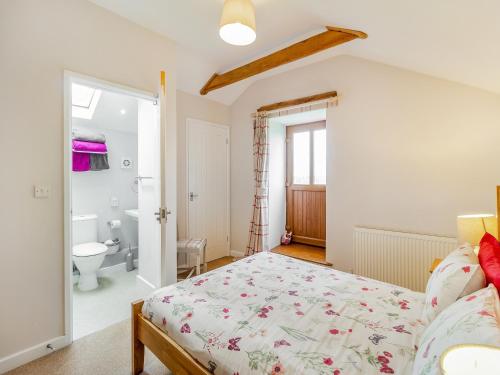 a bedroom with a bed and a bathroom at The Gallops in Llancarvan