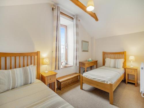 a bedroom with two beds and a window at The Gallops in Llancarfan