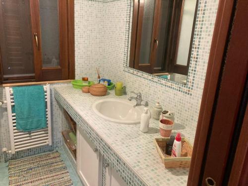 La salle de bains est pourvue d'un lavabo et d'un miroir. dans l'établissement Villa Greta a Sciacca 3 camere da letto, 6 posti letto, à Sciacca