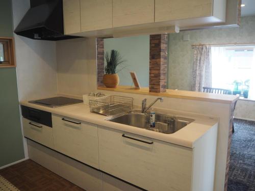 a kitchen with a sink and a counter top at CANAL HOUSE BOSTONS in Niigata