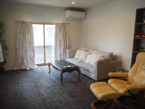 ein Wohnzimmer mit einem Sofa und einem Couchtisch in der Unterkunft CANAL HOUSE BOSTONS in Niigata