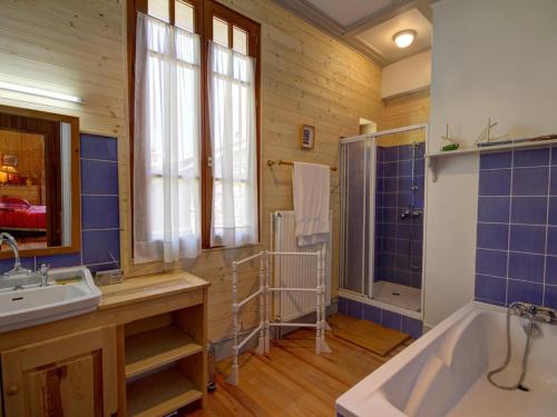 a bathroom with blue tiles and a tub and a sink at Chalet familial spacieux avec sauna au cœur du Parc du Pilat - FR-1-496-24 in Le Bessat