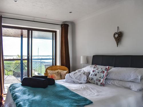 a bedroom with a bed with a view of the ocean at Riverview in Burnham on Crouch