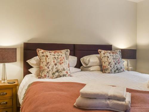 a bedroom with a large bed with pillows at Ivy Cottage in Dent