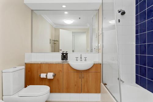 a bathroom with a sink and a toilet and a mirror at Perth Cbd Oasis Murray Street Studio in Perth