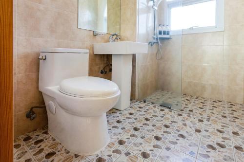 a bathroom with a toilet and a sink and a shower at The Bay Jeju Resort in Seogwipo