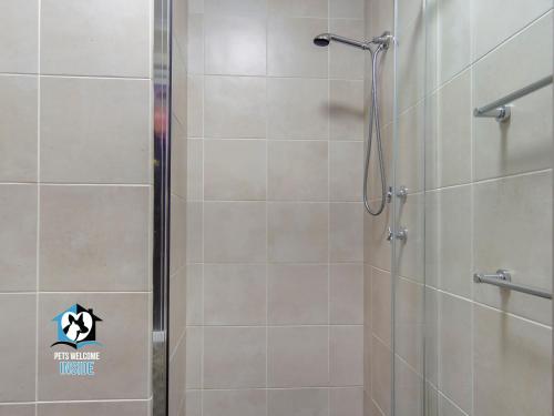 a bathroom with a shower with a glass door at Stylish 3BR Lake - front House in Encounter Bay