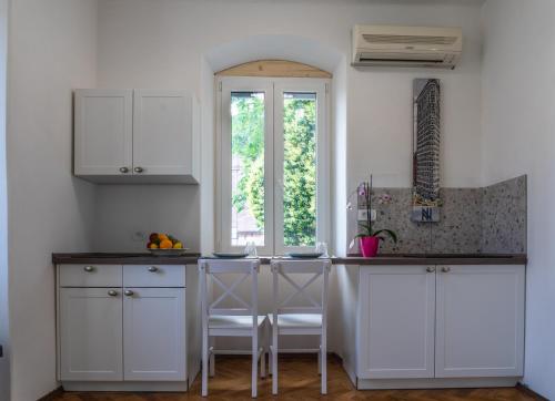 een keuken met witte kasten en een aanrecht met een raam bij Sunny terrace in Split